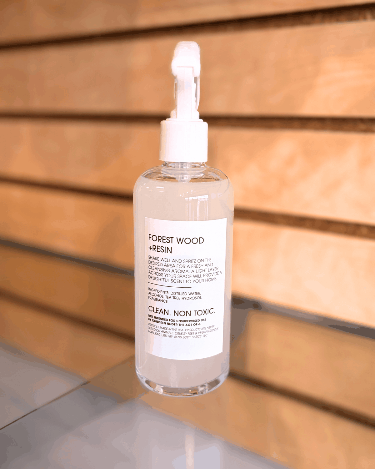 Santal 318 Room Spray in a clear bottle with a white trigger sprayer and a simple white Forest Wood + Resin label