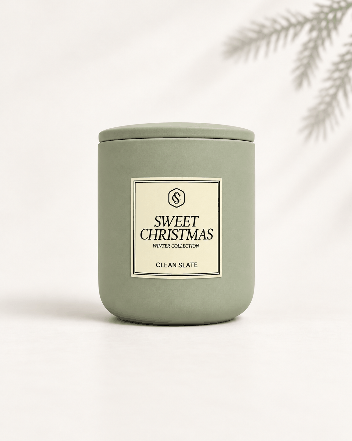 Sweet Christmas candle in a muted sage green ceramic jar with a fitted lid and cream rectangular label